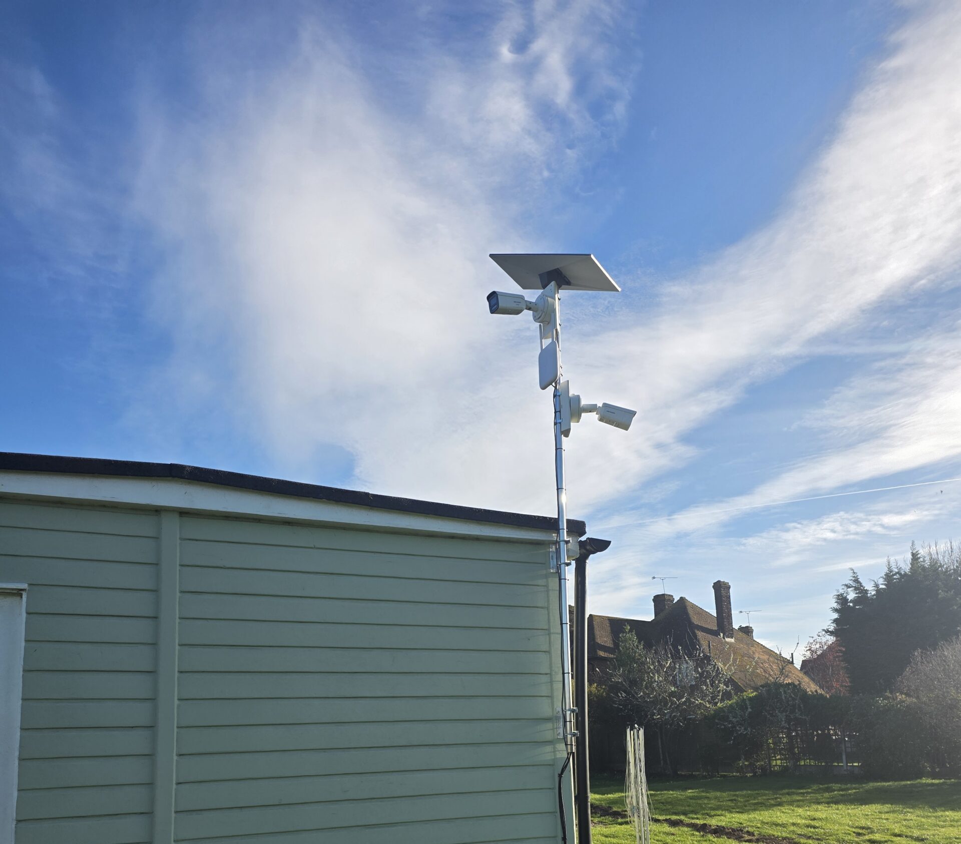 A wireless access point mounted on the exterior wall of a commercial building to extend outdoor Wi-Fi coverage.
