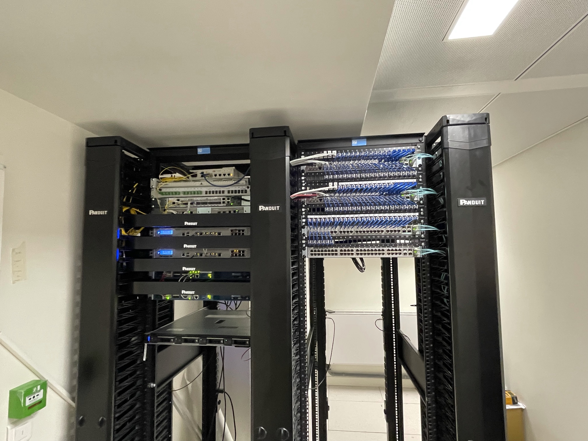 A server room containing multiple open‑frame network racks fitted with patch panels, switches, and structured cabling for a commercial network deployment.